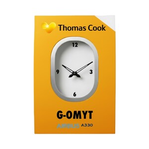May include: A yellow and white clock with the Thomas Cook logo. The clock face is white with black hands and numbers. The bottom of the clock has the text "G-OMYT" and "AIRBUS A330".