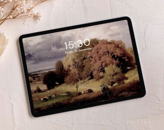 Może przedstawiać: Tablet cyfrowy wyświetlający obraz krajobrazu z zachmurzonym niebem, drzewami i polem z krowami. Godzina to 15:30, a data to piątek, 10 grudnia.