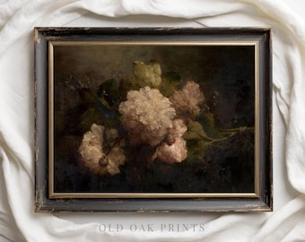 Puede incluir: Una impresión floral enmarcada que presenta una naturaleza muerta de flores blanco crema y rosa rubor con hojas verdes sobre un fondo oscuro. El marco es negro con ribete dorado. El texto "OLD OAK PRINTS" está en la parte inferior.