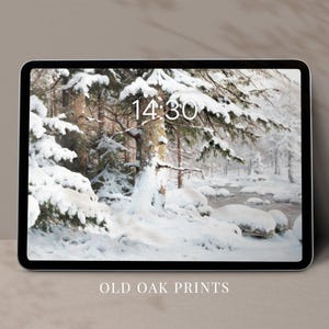 May include: A tablet shows a winter scene with snow-laden trees and a river. The time 14:30 is displayed on the screen. The text "OLD OAK PRINTS" is at the bottom of the tablet.