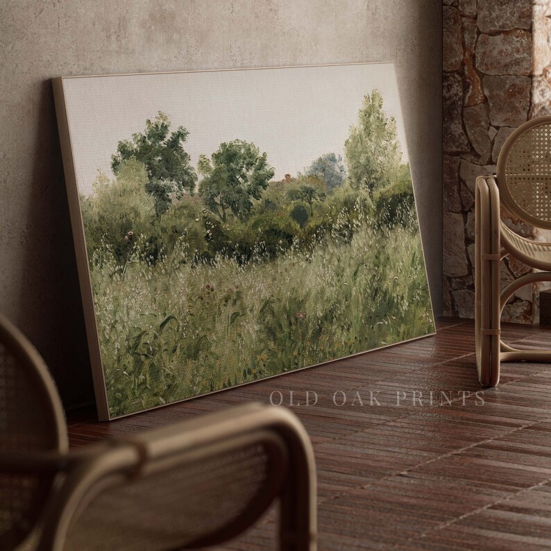May include: A painting depicting a green field with trees in the background. The painting is framed and hanging on a wall.
