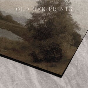 May include: A vintage-style print of a landscape scene with a river winding through a forest. The print is in shades of brown and gray, with a soft, muted color palette. The text "OLD OAK PRINTS" is visible in the upper right corner of the print.