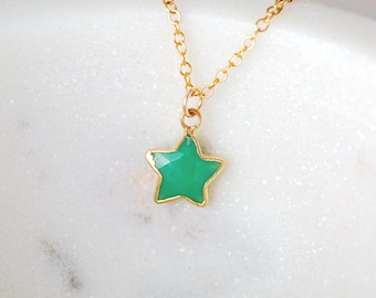 May include: A gold chain necklace with a green star-shaped pendant.