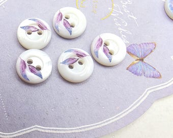 May include: Five round white buttons with two holes each, featuring a printed design of purple and blue leaves. The buttons are arranged on a light purple card that displays the text Best Wishes and a graphic of a purple butterfly.