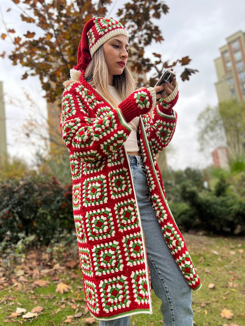 May include: A red, white, and green crochet cardigan with a matching hat. The cardigan has a long, loose fit and is made with a granny square pattern.