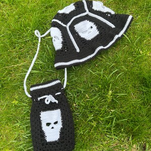 May include: Black and white crocheted bucket hat and matching drawstring bag with skull designs.