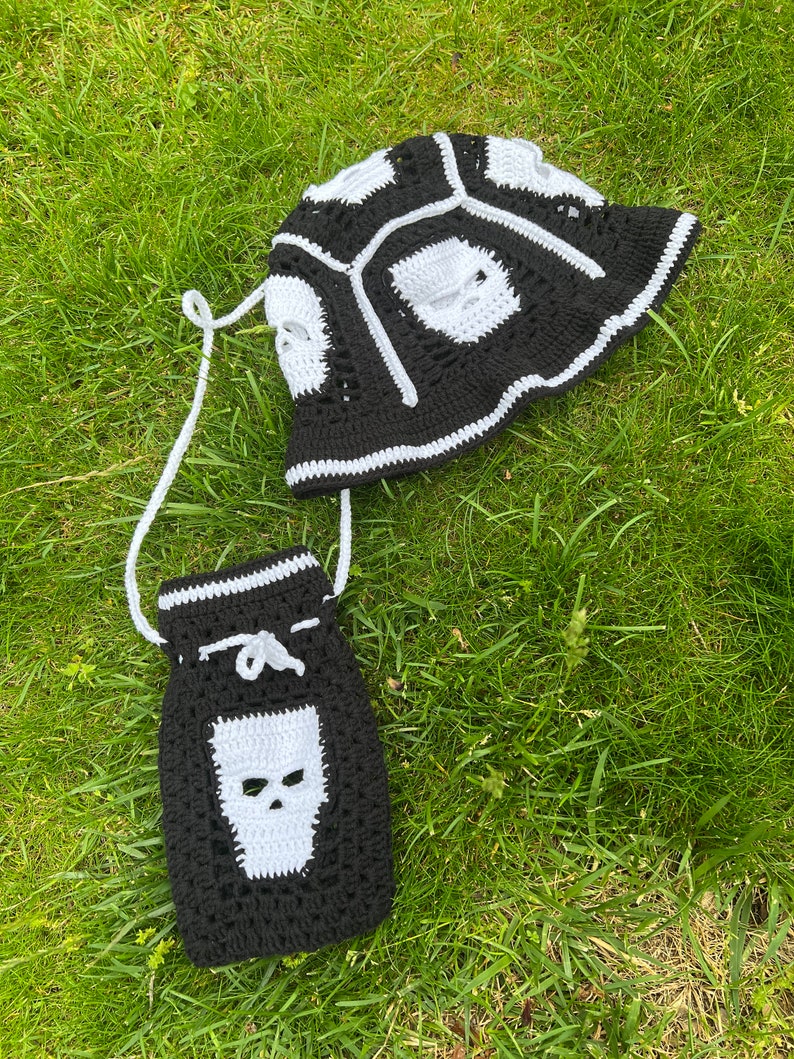 May include: Black and white crocheted bucket hat and matching drawstring bag with skull designs.