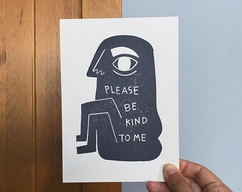 May include: A black and white illustration of a person with the text "PLEASE BE KIND TO ME" printed on the body.