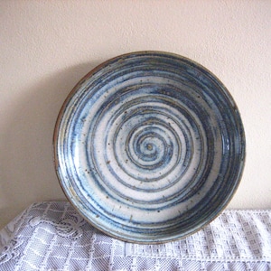 May include: A white ceramic bowl with a blue and brown spiral design.