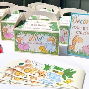 May include: A set of six colorful party favor boxes with a jungle animal theme. The boxes are decorated with a green, brown, and yellow jungle scene with a variety of animals, including a giraffe, elephant, monkey, and hippopotamus. The boxes are labeled "John's 1st Birthday" and "Wild Animal Rescue". A sign reads "Decorate your animal carrier".