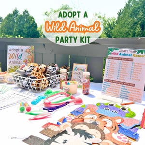 May include: A table set up for a wild animal themed party with stuffed animals, party favors, and a sign that says "What's Your Wild Animal Name?"