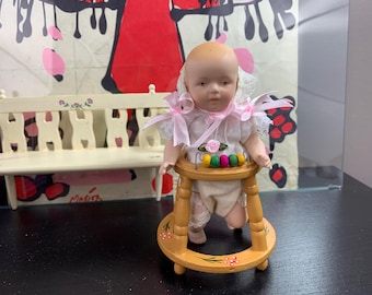 Porcelain doll in walker - mint condition - doll with movable arms and legs.