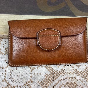 Bolso de piel con división de 3 compartimentos en color dorado.