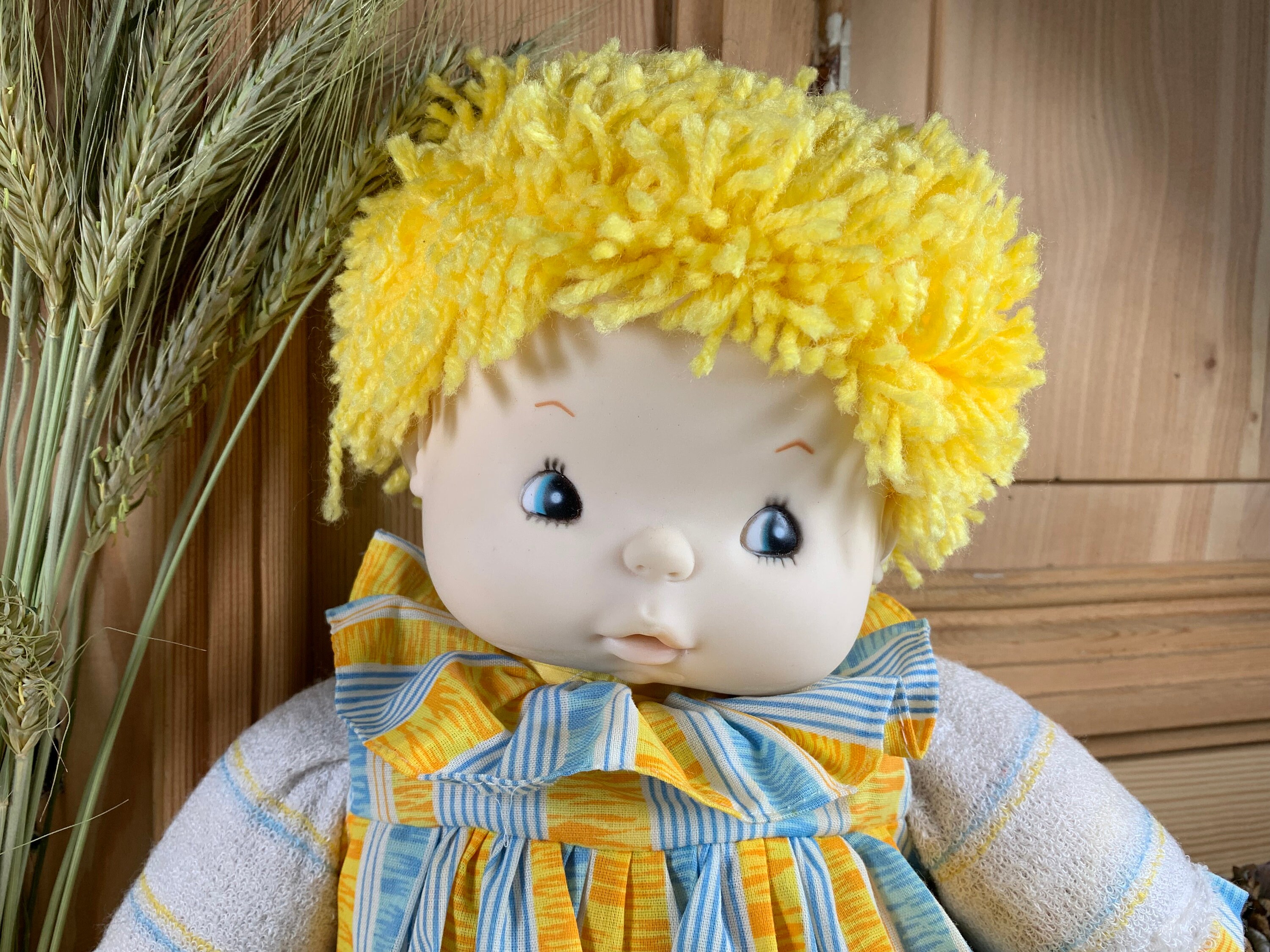A real charmer, this cuddly doll - rag doll - with its yellow yarn hair - in excellent condition