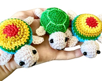 May include: Three crocheted turtle toys. One is green, one is yellow, red, and blue, and one is yellow, red, and blue with a pink belly.