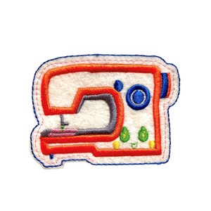 May include: A red, white, and blue embroidered sewing machine patch. The machine has a gray arm and a pink bobbin.