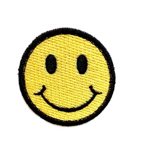 Puede incluir: Un parche bordado con una carita sonriente amarilla con contorno negro.