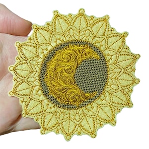 Peut inclure: Patch brodé or en or avec un motif de croissant de lune entouré d'un motif de mandala circulaire.