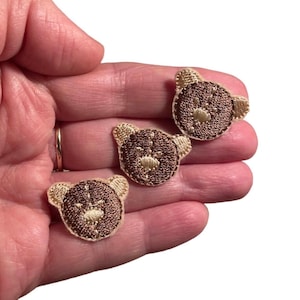 Op de afbeelding: Drie bruine geborduurde berenkop-patches met beige stiksels. De patches zijn ongeveer 2,5 cm in diameter.