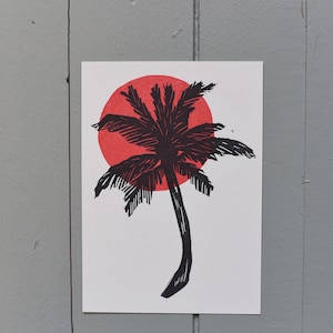 Palmier au soleil rouge : carte postale en linoléum
