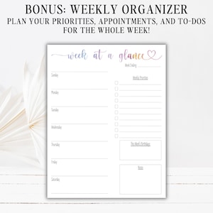 May include: A white weekly planner sheet with the text "week at a glance" in a gradient purple and orange script font. The layout includes sections for Sunday through Saturday, a checklist for weekly priorities, a birthday box, and a notes section.