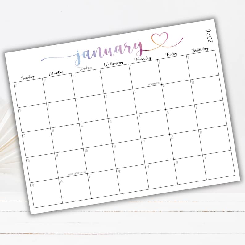 May include: A January 2026 monthly calendar page with a white background and black grid lines. The word January is written in a purple and orange gradient script font with a heart icon. The calendar includes days of the week and dates.