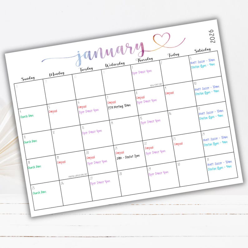 May include: A January 2026 wall calendar page with a watercolor-style gradient header and a heart icon. The grid features black lines and handwritten-style text entries in various colors, including carpool, dance, soccer, and church schedules.
