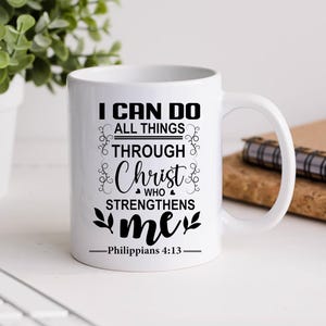 May include: White ceramic coffee mug with black text that reads "I can do all things through Christ who strengthens me - Philippians 4:13".