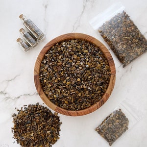 May include: A wooden bowl filled with brown tiger's eye chips. There are three small glass bottles filled with tiger's eye chips and two small plastic bags filled with tiger's eye chips.