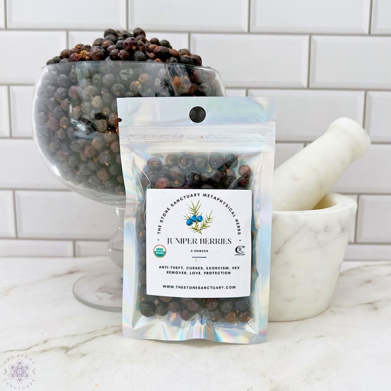 May include: A clear plastic bag with a white label that reads "The Stone Sanctuary Metaphysical Herbs Juniper Berries 1 Ounces Anti-theft, Curses, Exorcism, Hex Remover, Love, Protection www.thestonesanctuary.com". The bag contains dark blue juniper berries.