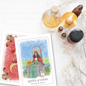 May include: Two tarot cards are displayed, one with a red and gold floral design, and the other featuring a seated woman with the text "QUEEN of COINS, Nurturing & Security." The image includes essential oils, a candle, and dried flowers.