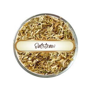 May include: A clear glass bowl filled with dried oatstraw. A white and gold label across the center of the bowl reads "Oatstraw" in a cursive font. The oatstraw is a mix of light brown and green.