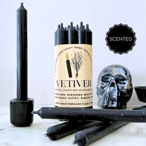 May include: Black Vetiver scented spell candles with a skull and candle holder. The candles are packaged with a label that reads "VETIVER" and "THE STONE SANCTUARY SHOP ESTABLISHED". The image also includes the word "SCENTED".