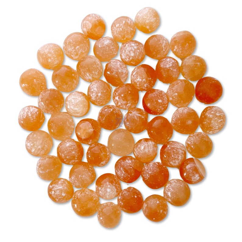 May include: A collection of approximately 40 orange carnelian tumbled stones. The stones are smooth and have a speckled white pattern.