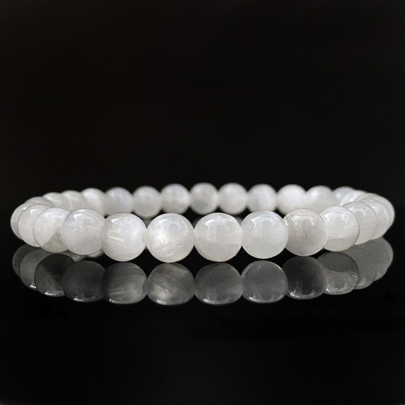 Peut inclure: Un bracelet en pierre de lune blanche avec des perles rondes. Le bracelet est fait de pierres naturelles et a une finition polie.