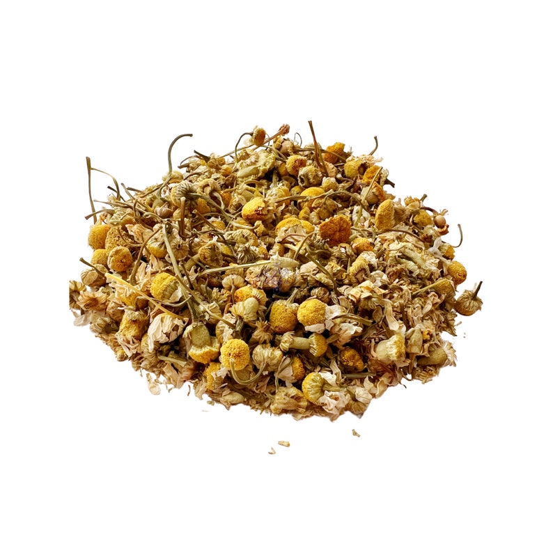 May include: A pile of dried chamomile flowers, featuring small, yellow, and white blossoms with thin, brown stems. The image is set against a clean white background, highlighting the natural texture and color of the herbal tea.
