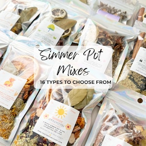 May include: A collection of simmer pot mixes in iridescent, resealable pouches. Each pouch contains dried botanicals, citrus slices, and spices. Labels feature text including Simmer Pot Mixes, 16 Types To Choose From, and specific blend names.