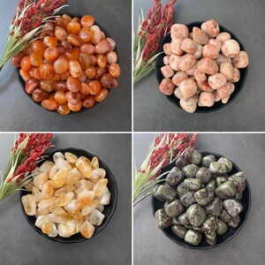 May include: Four bowls of tumbled stones, each bowl containing a different type of stone. The bowls are black and the stones are various colors, including red, orange, yellow, green, and brown.