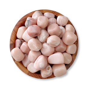 May include: A wooden bowl filled with smooth, tumbled pink stones. The stones vary in shade from pale to medium pink, with some showing subtle white marbling. The bowl is made of light brown wood, and the stones are the primary focus.