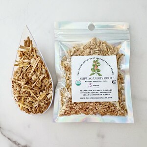 May include: A clear scoop and a sealed bag filled with dried ashwagandha root. The bag has a label with text that reads "ASHWAGANDHA ROOT" and "The Stone Sanctuary Metaphysical Herbs". The bag contains 0.5 ounces of the product.