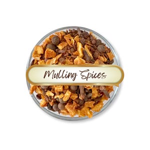 May include: A clear glass bowl filled with mulling spices, including pieces of dried fruit, cloves, and peppercorns. The words "Mulling Spices" are written on a gold-edged label across the bowl. The spices are a mix of brown, orange, and dark colors.