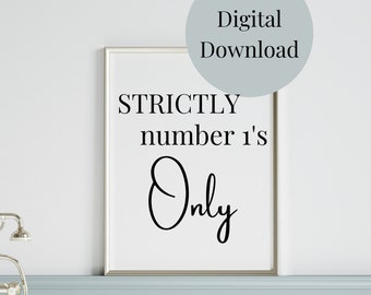 May include: A white framed print with black text that reads "STRICTLY number 1's Only". The print is hanging on a light blue wall above a white bathtub.