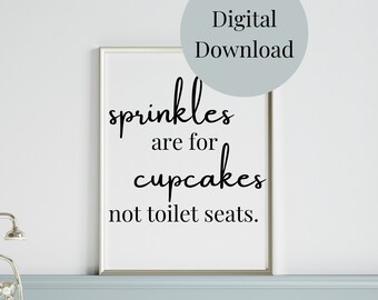 May include: A framed print with the text "sprinkles are for cupcakes not toilet seats" in black script. The print is in a bathroom setting, with a white bathtub and silver faucet visible. A digital download graphic is in the upper right corner.