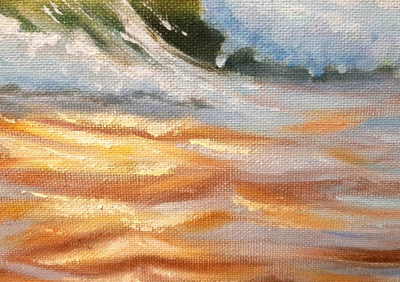 May include: A close-up of a painting depicting a sandy beach with waves crashing on the shore. The painting is done in a realistic style with a focus on the texture of the sand and the water.