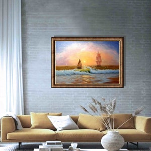 May include: A painting of a seascape with two sailboats on the water. The sky is a soft pink and orange, and the water is a deep blue. The painting is framed in a brown frame.