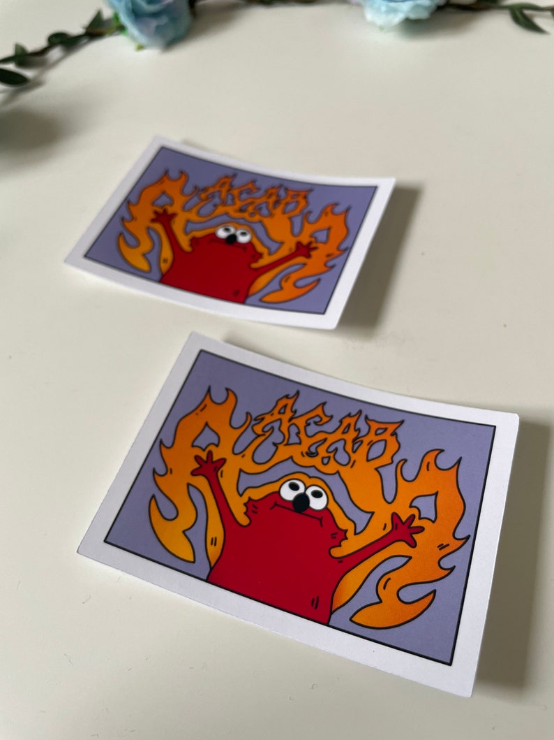 May include: A red cartoon character with big eyes is on fire. The flames are orange and yellow and spell out the word "AGAB". The character is on a purple background.