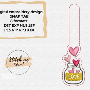 Pode incluir: Um design de bordado digital de um frasco com corações e a palavra "LOVE" nele. O design é para uma aba de pressão e está disponível em 8 formatos: DST, EXP, HUS, JEF, PES, VIP, VP3 e XXX.