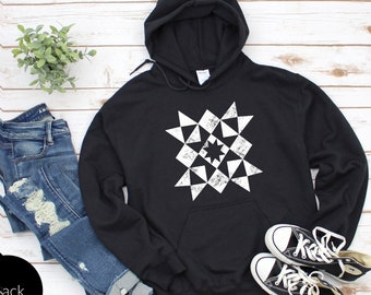 May include: Black hooded sweatshirt with a white geometric starburst design. The sweatshirt is made of a soft, comfortable material and has a relaxed fit.