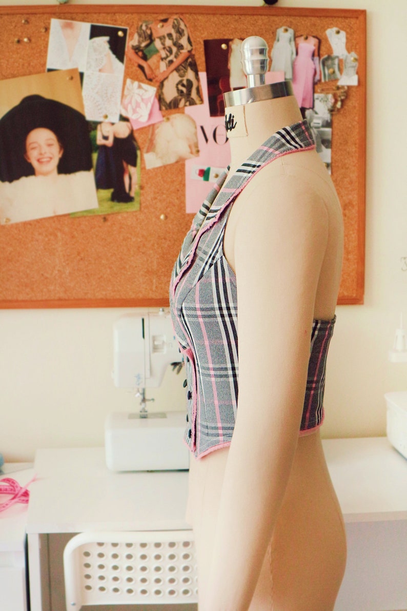 View of the vest from the side. You can see that the vest is held on the neck with a collar.
The shoulders are completely open.The vest is worn over the head on the neck.