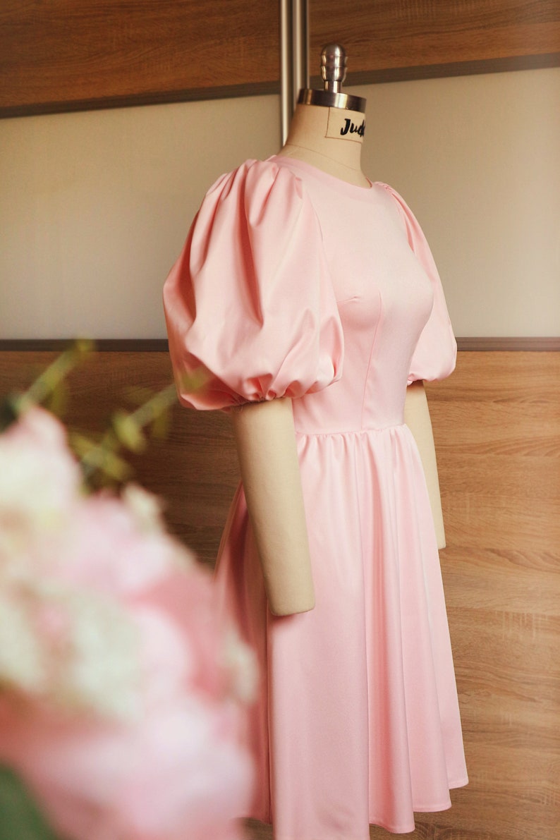 The dress is worn on a mannequin full-length view from the side.On the upper part of the dress front, the breast dart and waist dart are visible.